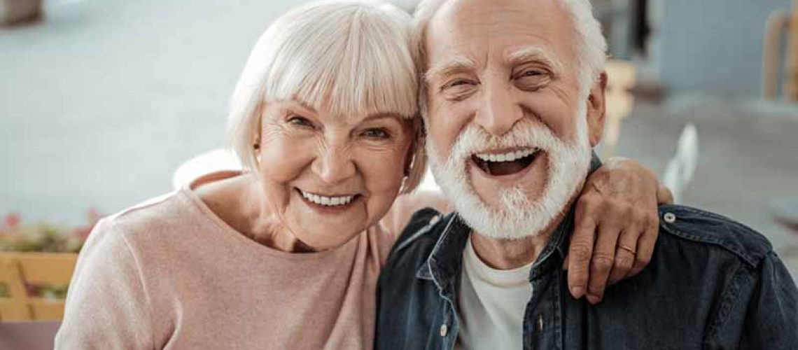 a couple smiling with their all on 4 dental implants