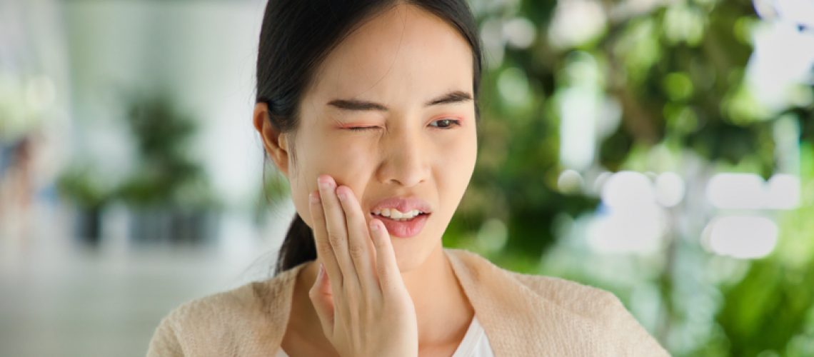 Young woman suffering from toothache, tooth decay, tooth sensitivity, wisdom tooth pain, cavity, dental care concept